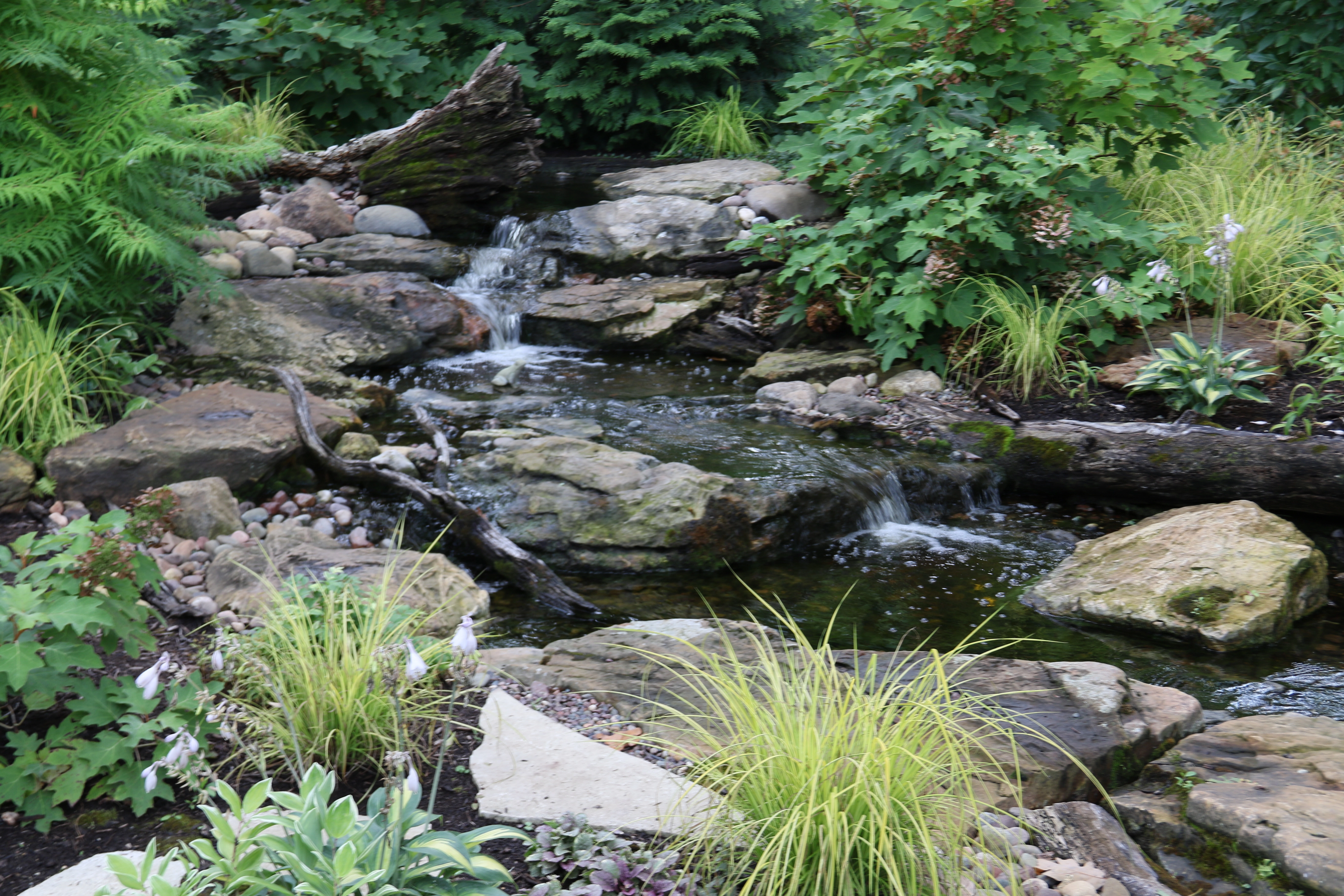 Pondless waterfall with moving water and natural stone landscape