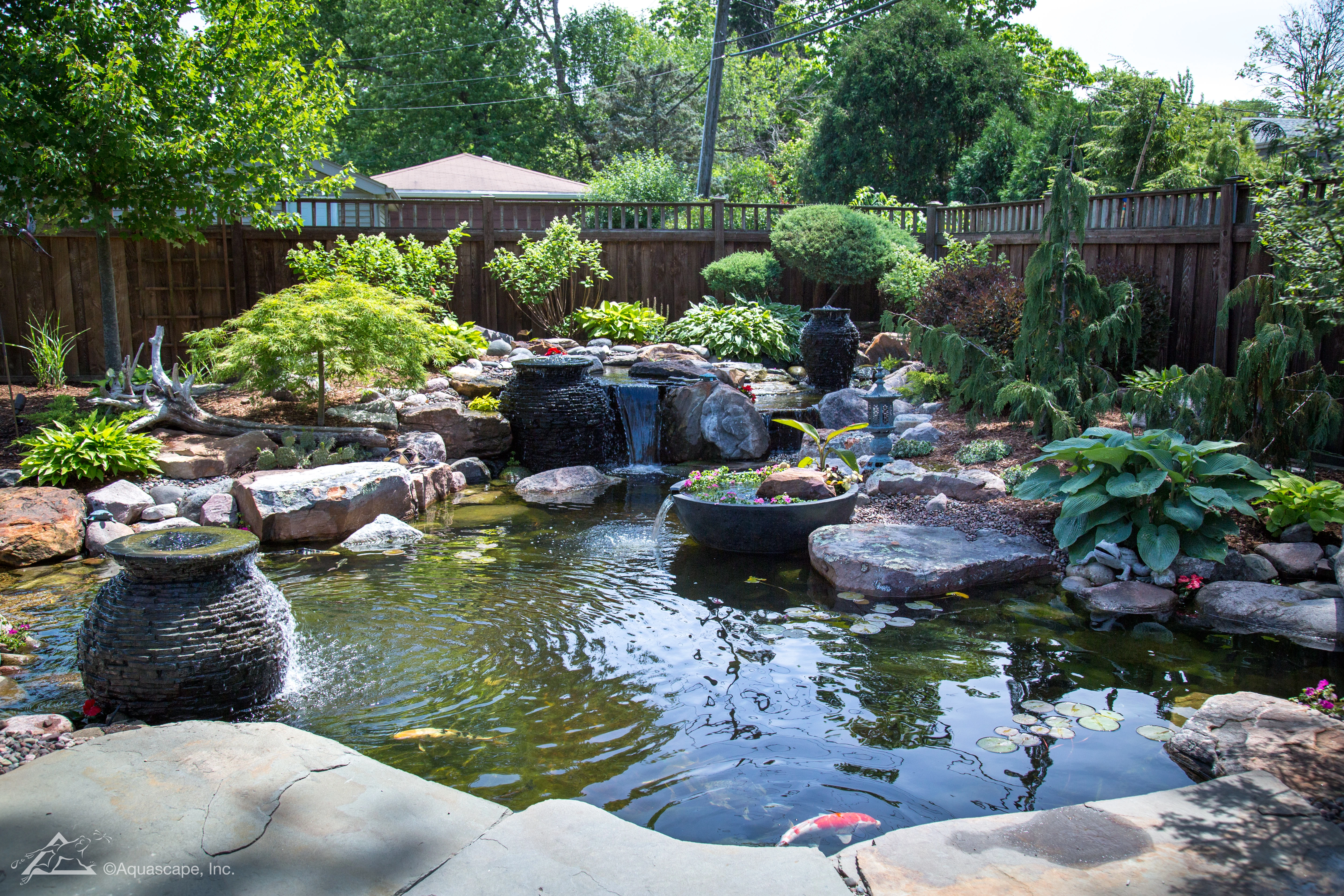 Backyard ecosystem pond with fountains and natural stonework in Minnesota