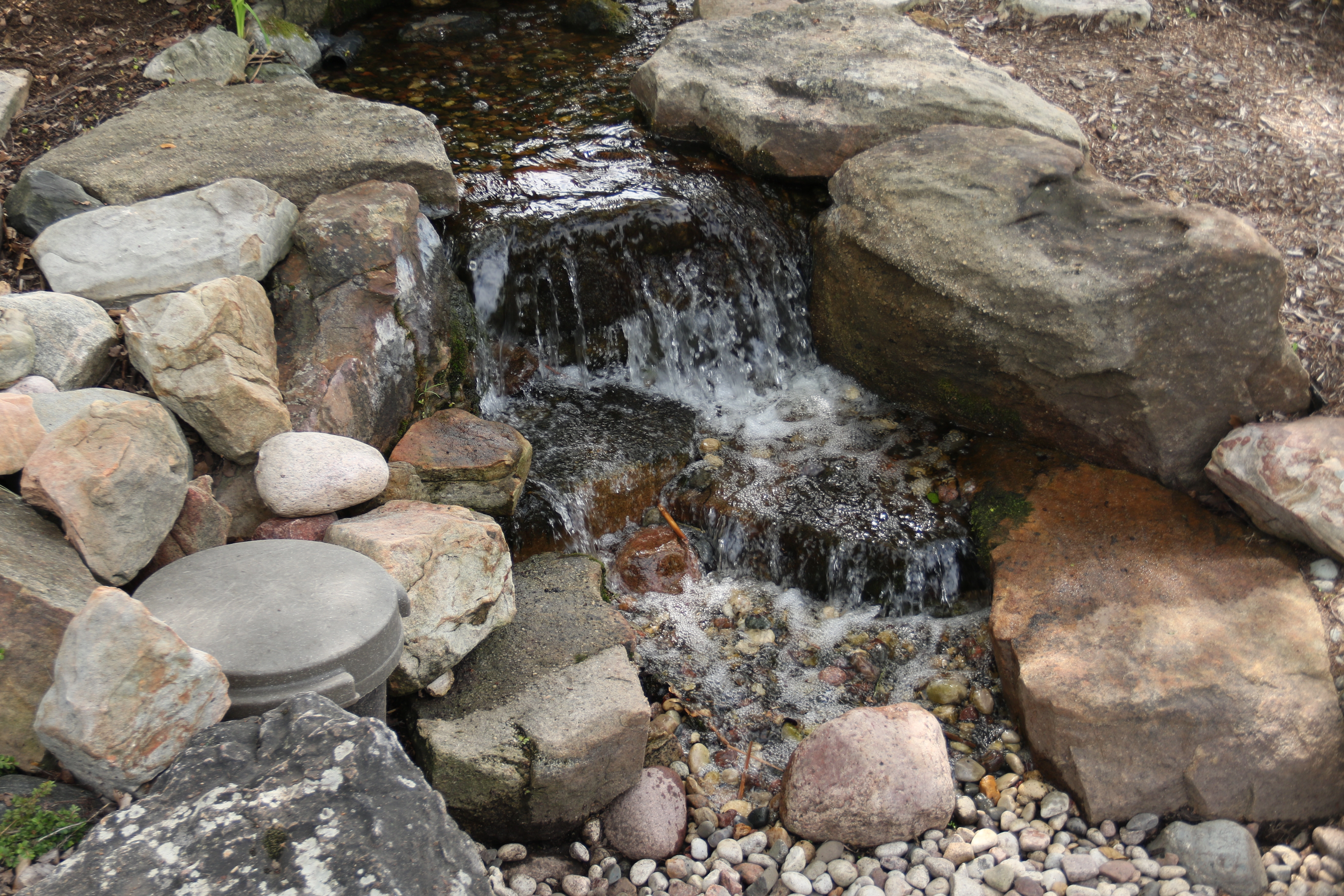 Natural pondless waterfall with stream and stonework in Burnsville Minnesota