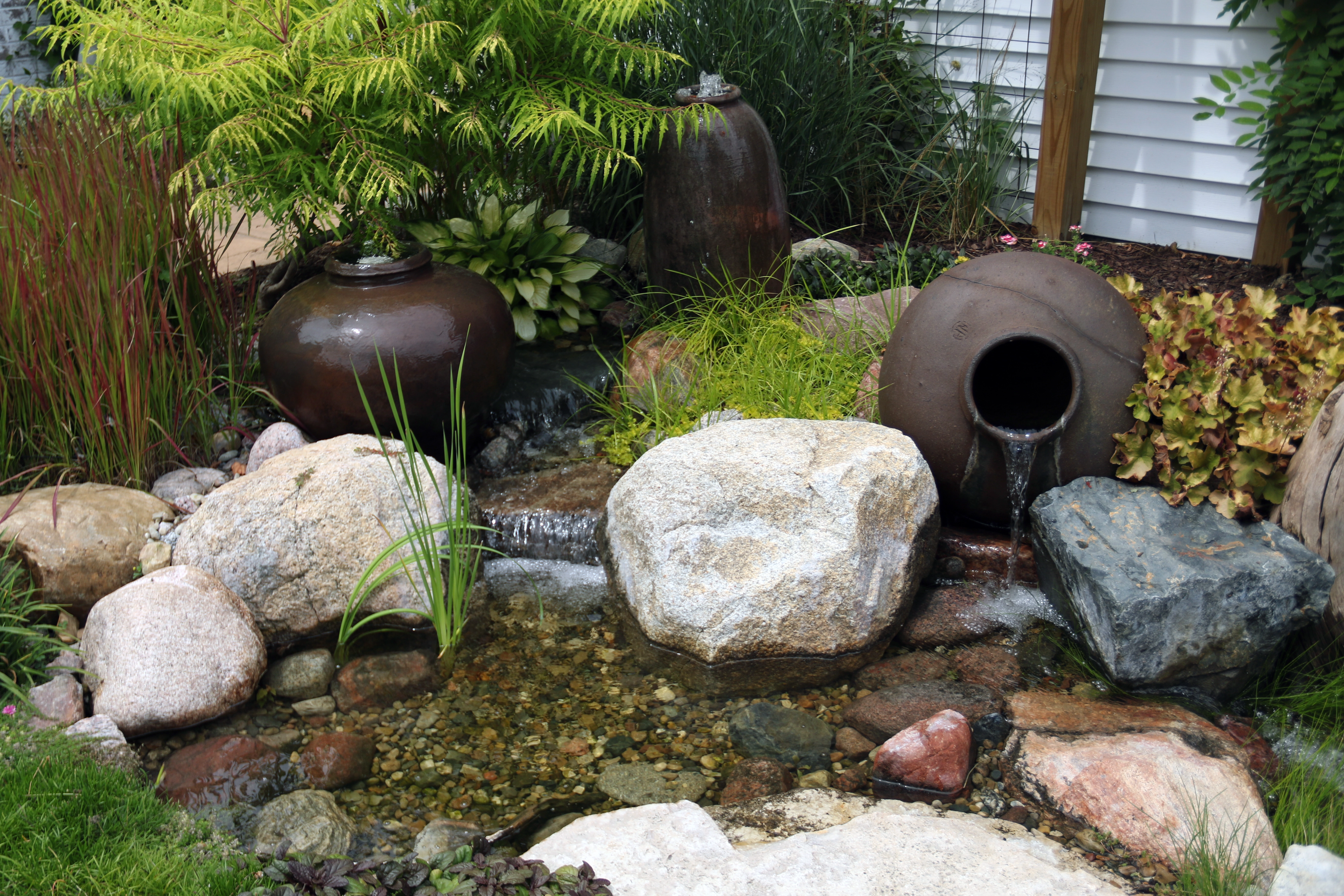Small pondless waterfall installed near an existing home