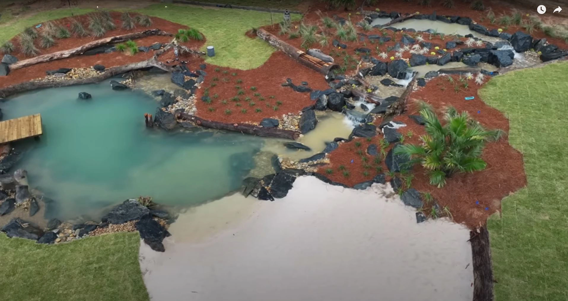 Large ecosystem pond and waterfall construction site showing excavation and landscape layout