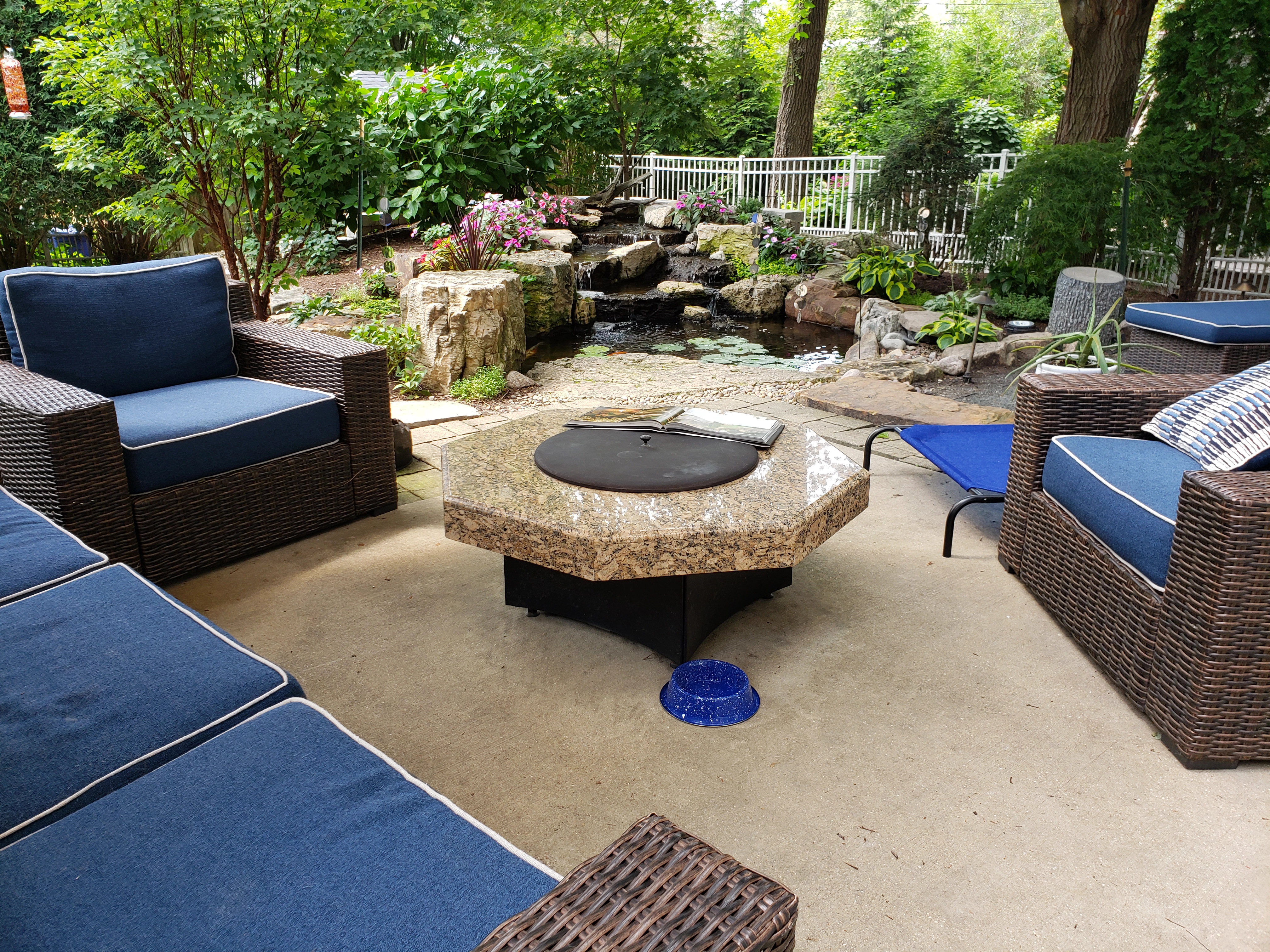 Backyard patio seating area overlooking a pond and waterfall in Fairmont Minnesota