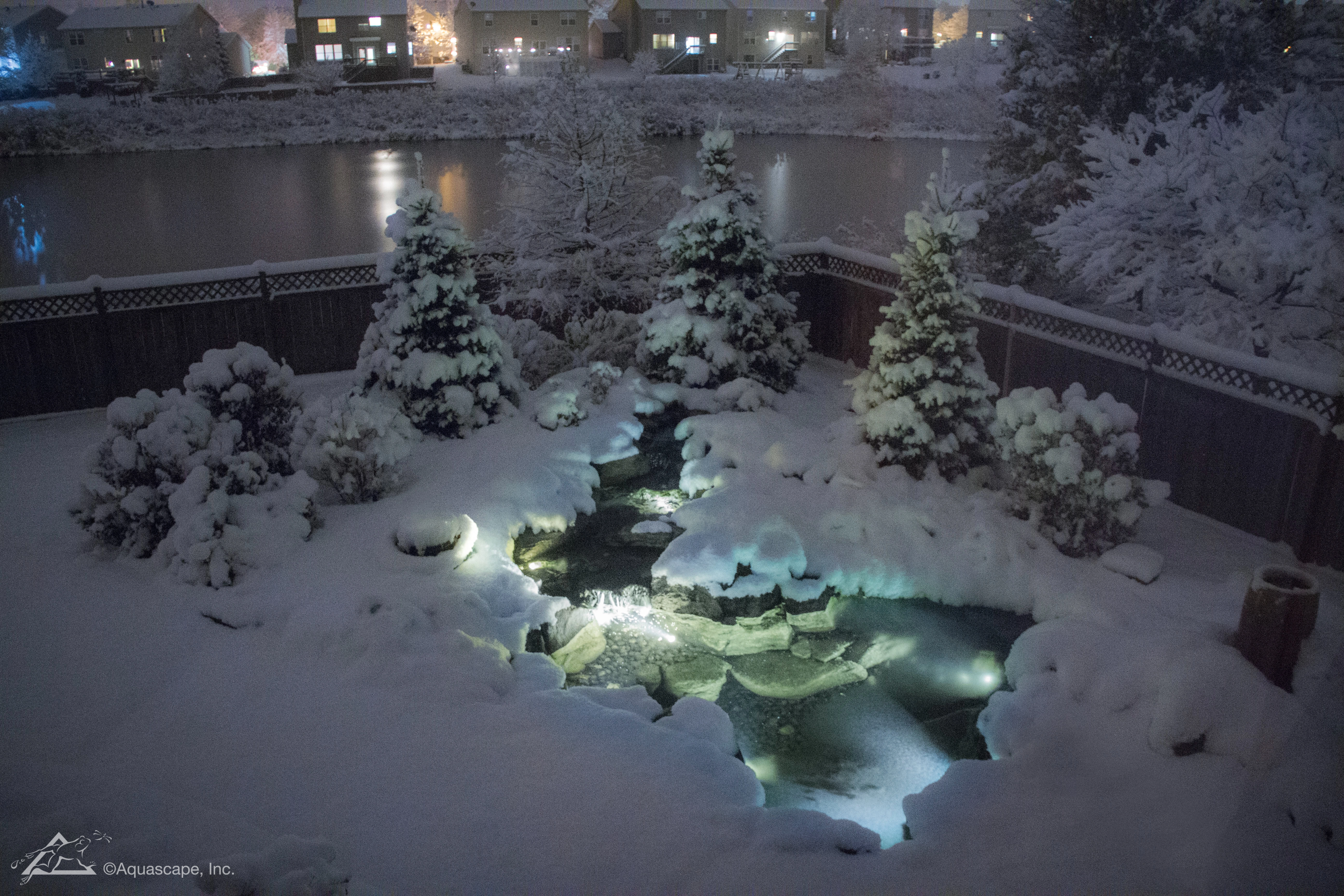 A night-time fully lit up snow covered pond in St. Charles, Illinois