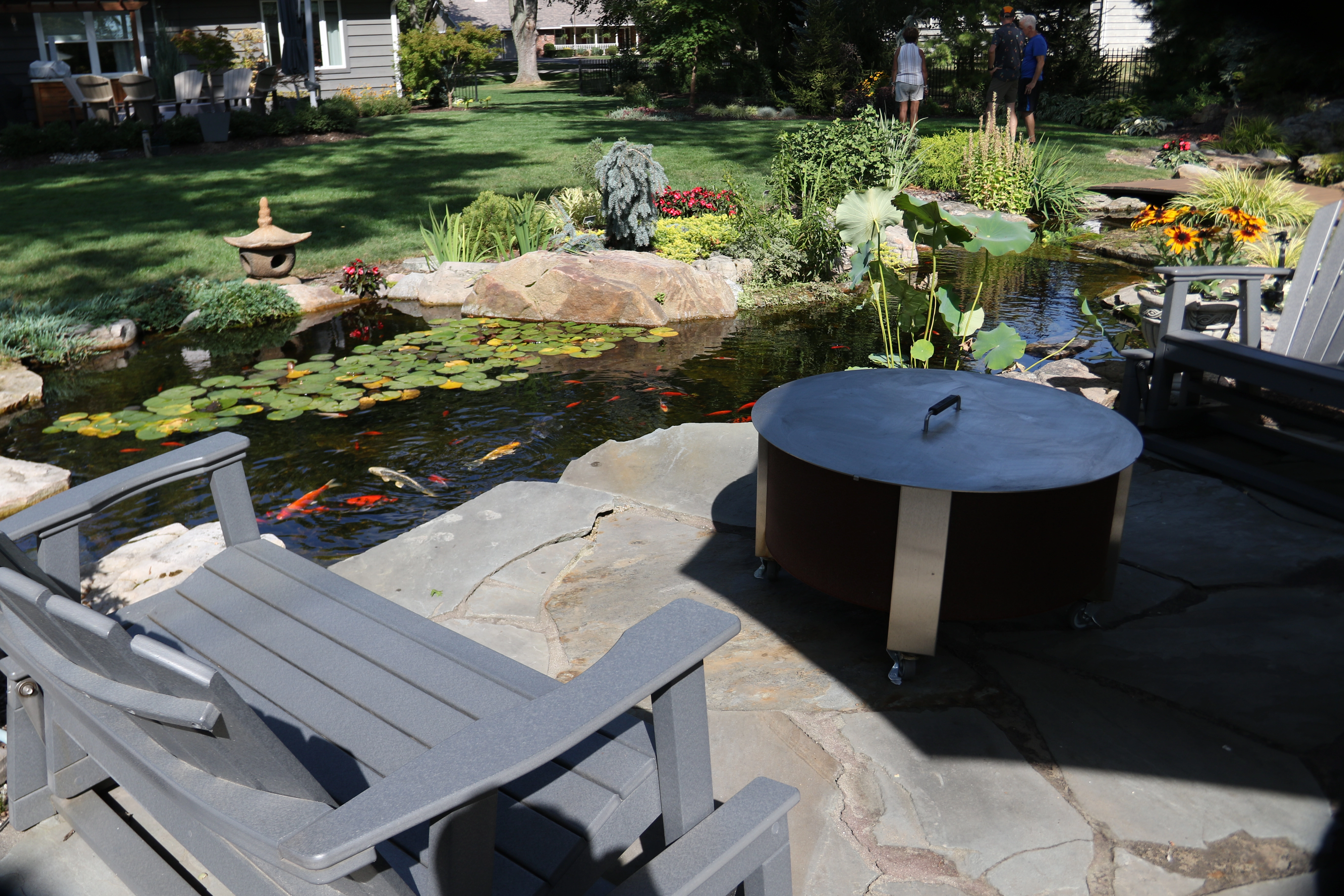 Ecosystem pond with koi beside a backyard patio in Jordan Minnesota
