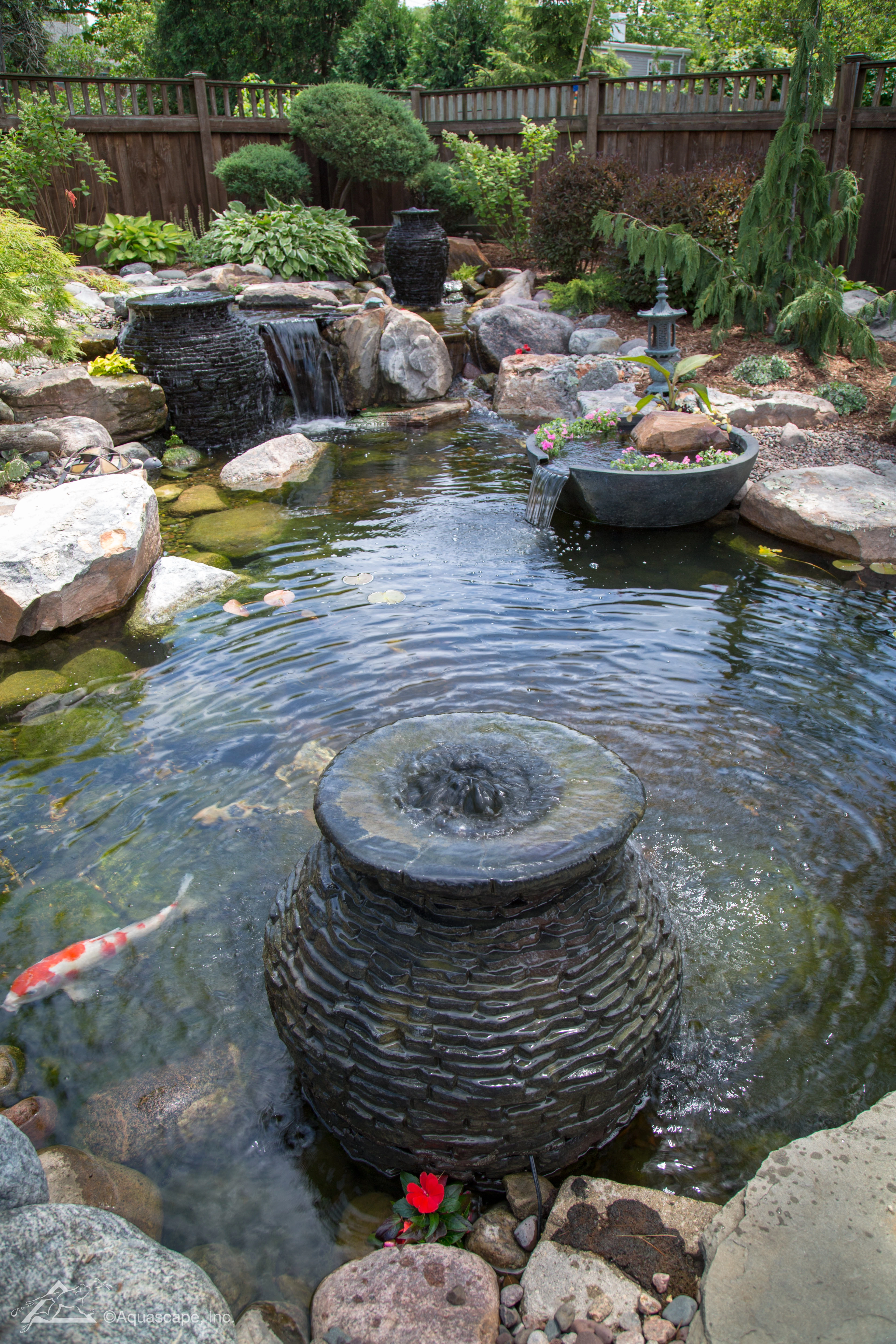 Decorative fountain bowl added to a pond and waterfall in Marshall Minnesota