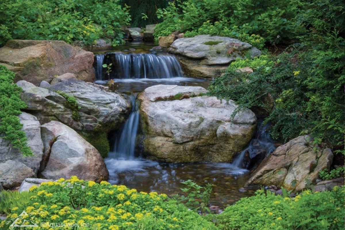 Medium pondless waterfall with natural stone and plantings in Owatonna Minnesota