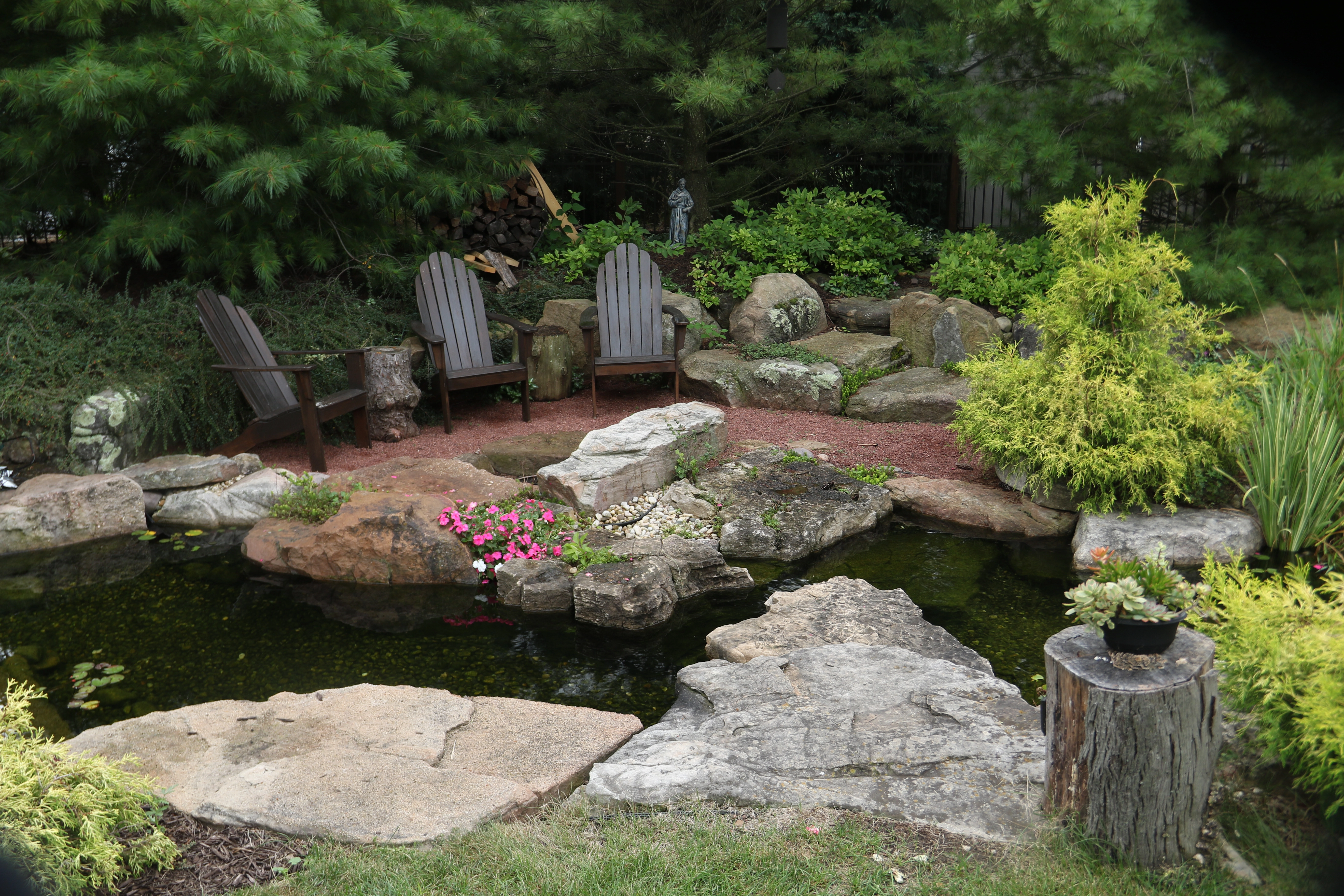 Pond stream with seating area for a Victoria Minnesota backyard