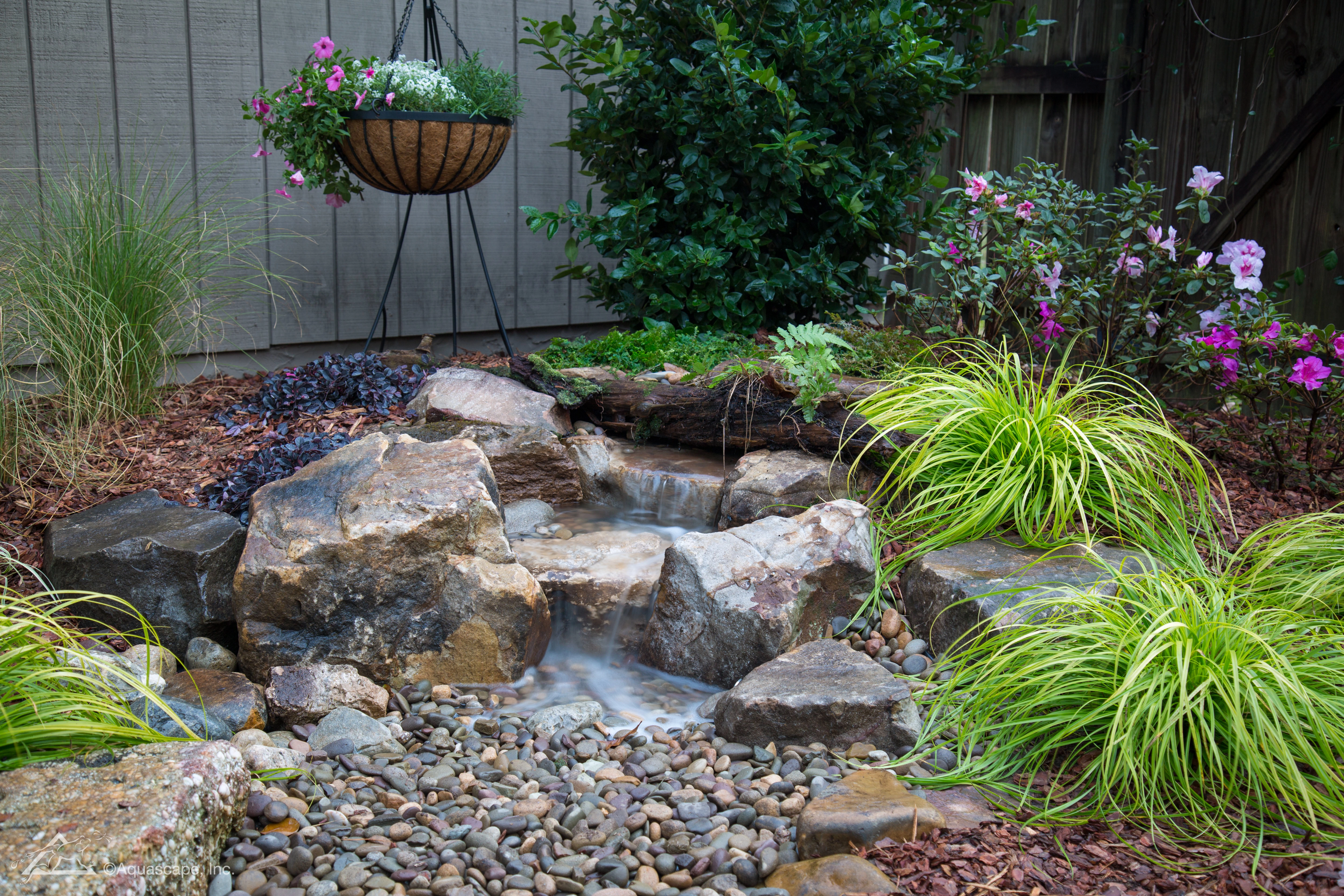 Small backyard waterfall integrated into landscaping